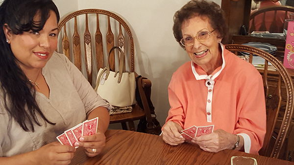 Caregiver and senior playing cards